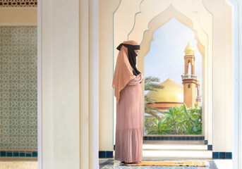 Muslim woman wearing Niqab and gesture pray at public Mosque (Islamic temple), beautiful arches of the Arab mosque, Muslim woman concept,