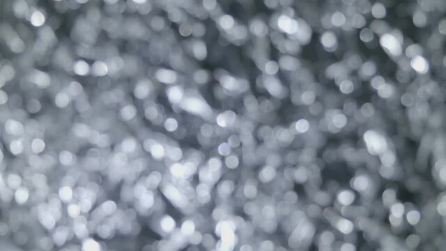 Background of silver color is shimmering of bright lights out of focus. Macro. Closeup