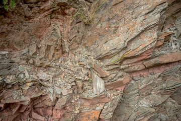 surface of cracked natural stone in which the reddish tones predominate