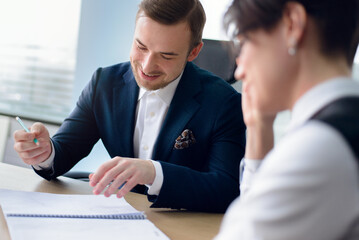Business people working together sitting at the table against a background of the office. 