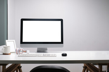 Modern workspace with computer with blank screen and equipment on white table.Blank screen for your...