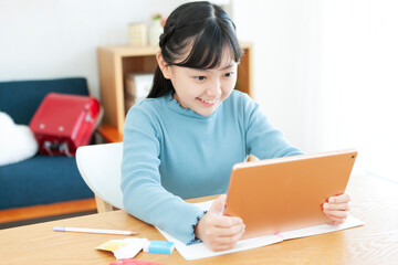 タブレット端末を見ながら勉強する女の子