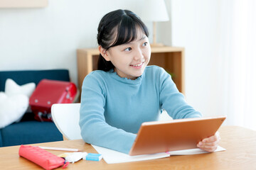 タブレット端末でリモート学習をする女の子