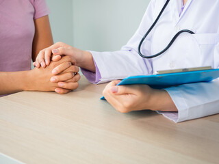 close up of doctor cosoulting a patiant in a hospital. giving comfort by holding hand. health care and medical care concept.