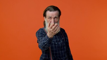 I choose you. Senior old bearded man pointing to camera and looking with playful happy expression, making choice, showing direction posing on orange studio background. Elderly grandfather pensioner
