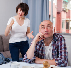 Domestic quarrel between offended husband and his wife at home. High quality photo