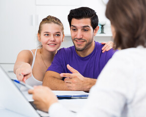 Happy young couple meeting financial adviser for investment at home