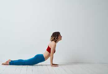 Fototapeta na wymiar Sporty Woman In A Bright Room And Does Yoga Asana Exercises