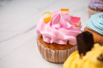 Delicious homemade cupcakes with Colorful cream and topping with candy and Chocolate Cookies. Homemade autumn holiday dessert