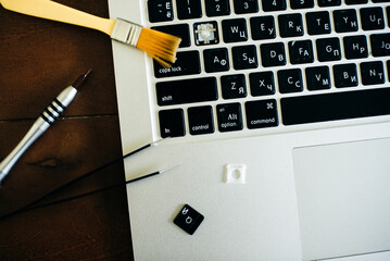screwdriver and spare parts from a laptop. Keyboard, brush, keys. Laptop repair