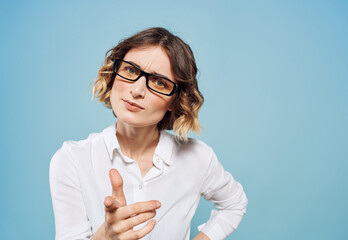 Puzzled look of a woman on a blue background gesturing with her hands cropped view