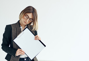 Naklejka premium a woman in a formal suit holds a white sheet of paper in her hands Copy Space