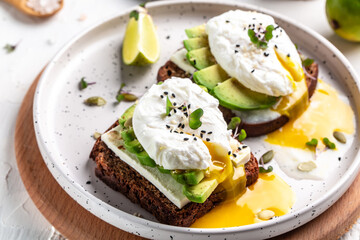 Sandwich with avocado and Poached Egg. Wholemeal Bread Toast sliced avocado and egg with cup of coffee for healthy breakfast or snack