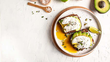 Fototapeta na wymiar Sandwich with avocado and poached egg. Healthy nutritious paleo keto breakfast concept