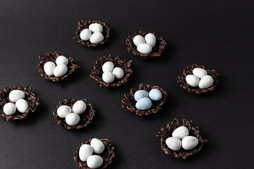 small Easter eggs in chocolate nests on a black background decoration