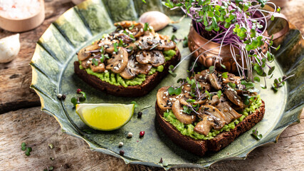 Toast avocado, mushrooms and microgreen whole grain sandwich. Decorated with sesame. Vegetarian...