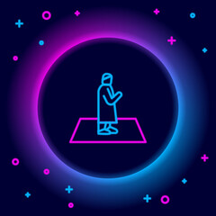 Glowing neon line Muslim man prays on the carpet icon isolated on black background. Colorful outline concept. Vector