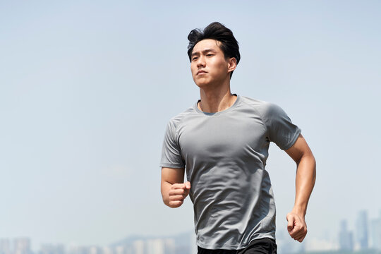 young asian man running outdoors