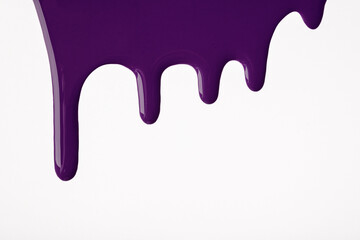 Dark purple liquid drops of paint color flow down on isolated white background. Abstract violet backdrop