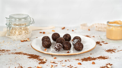 Super food energy balls. Homemade healthy raw vegan dessert on white plate with oatmeal and peanut butter. Healthy eating. Fitness snack. Selective focus