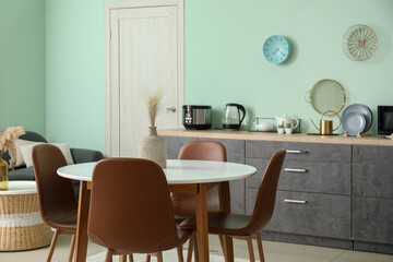 Fototapeta na wymiar Dining table and chairs in interior of modern kitchen
