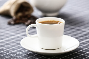 Cup of hot coffee on table in cafe, closeup