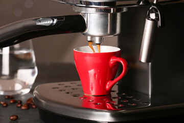 Modern coffee machine with cup of hot espresso in cafe