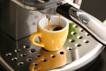 Modern coffee machine with cup of hot espresso in cafe