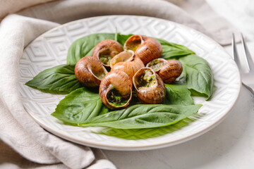 Plate with tasty snails on light background, closeup