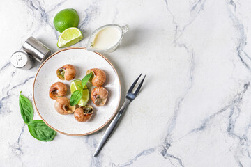 Plate with tasty snails on light background
