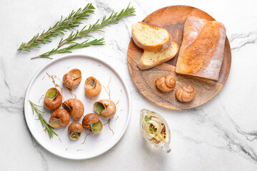 Plate with tasty snails on light background