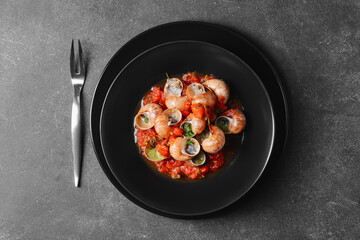 Plate with tasty snails on dark background
