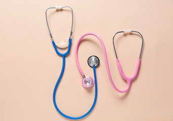 Modern stethoscopes on color background