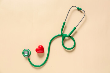 Modern stethoscope and heart on color background