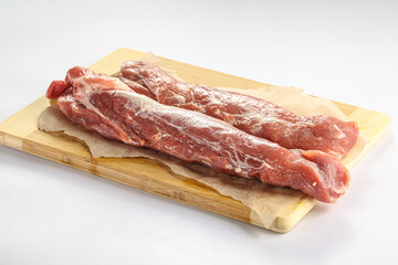Raw pork tenderloin over board