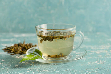 Cup of green tea on color background