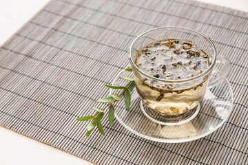 Cup of green tea on bamboo mat