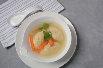 Griessnockerlsuppe. Clear Soup with Semolina Dumplings in a white bowl. German food.  Bavarian cuisine.