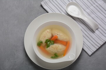 Griessnockerlsuppe. Clear Soup with Semolina Dumplings in a white bowl. German food.  Bavarian cuisine.