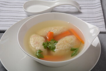 Griessnockerlsuppe. Clear Soup with Semolina Dumplings in a white bowl. German food.  Bavarian cuisine.