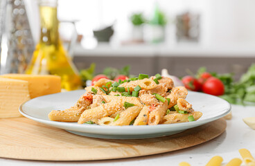 Plate with cajun chicken pasta on table in kitchen