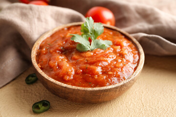 Bowl of tasty salsa on color background
