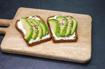 Breakfast concept. Bruschetta with cottage cheese, flax seeds, sesame and lime. Sandwiches with soft cheese. Toast is on the table. Healthy food, still life. Toast and spread on it. Healthy food.