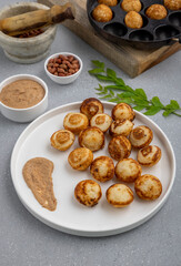 Suji appe or appam served on a appam pan with peanuts and tamarind chutney