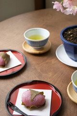 ちゃぶ台に置かれた桜餅（道明寺）と緑茶と桜の花