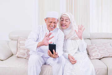 Muslim senior couple doing video call at home