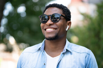 Man smiling while standing outdoors.