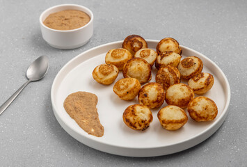 Suji appe or appam served on a appam pan with peanuts and tamarind chutney
