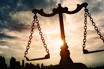 Scales of justice with dusk sky background