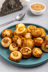 Suji appe or appam served on a appam pan with peanuts and tamarind chutney